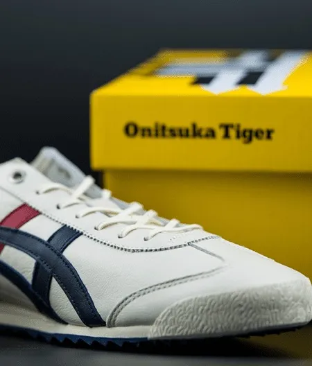 An Onitsuka Tiger sneaker beside its yellow shoebox