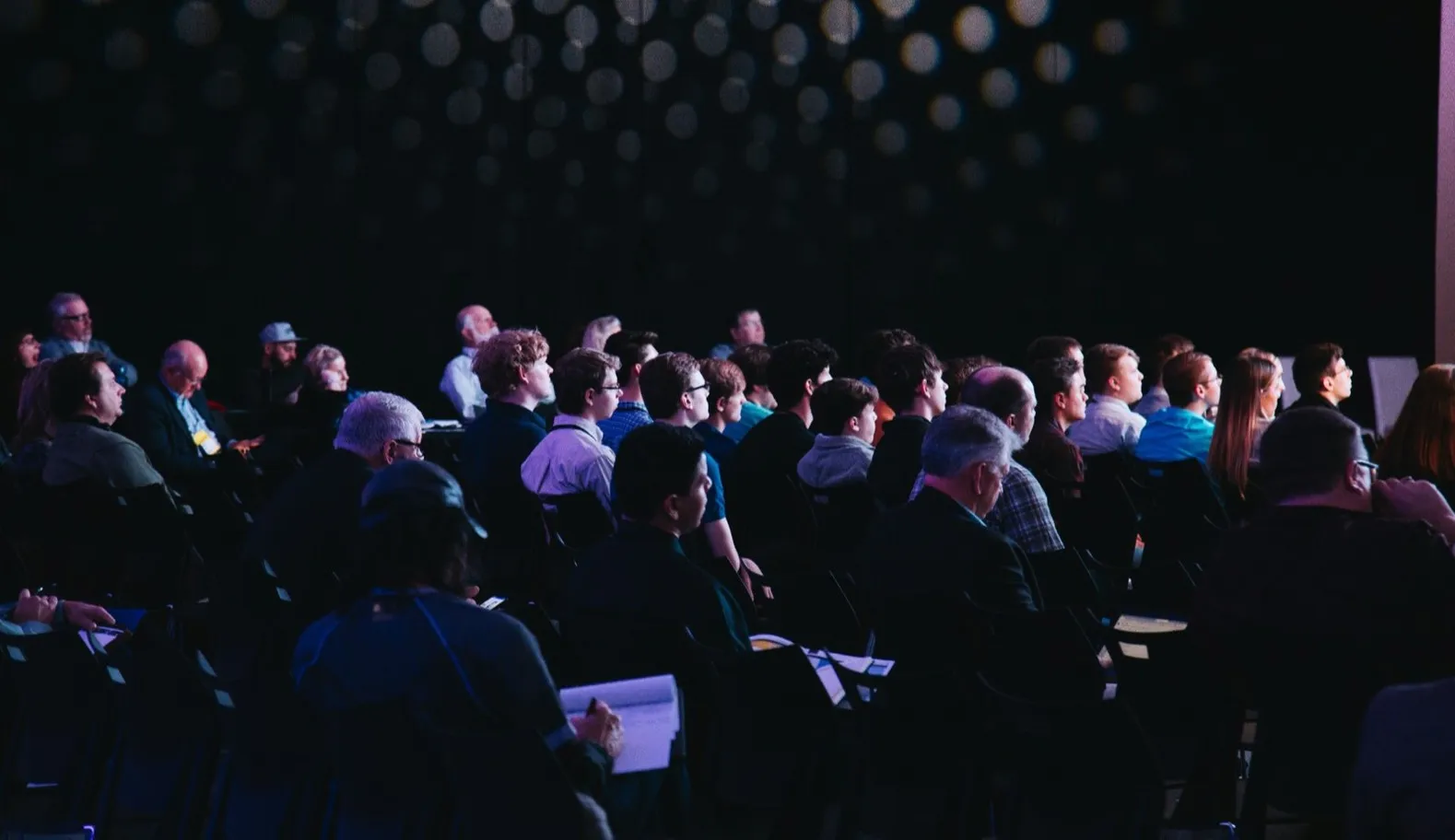 A full audience seated in a dimly lit hall during the awards ceremony