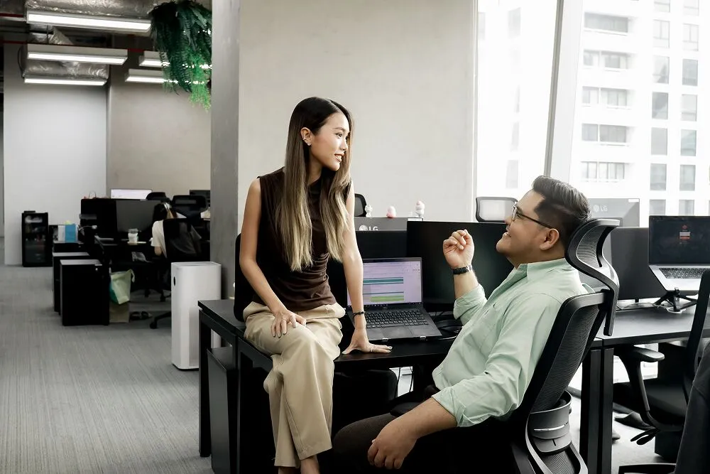 Two Primal colleagues laughing at a desk in the office