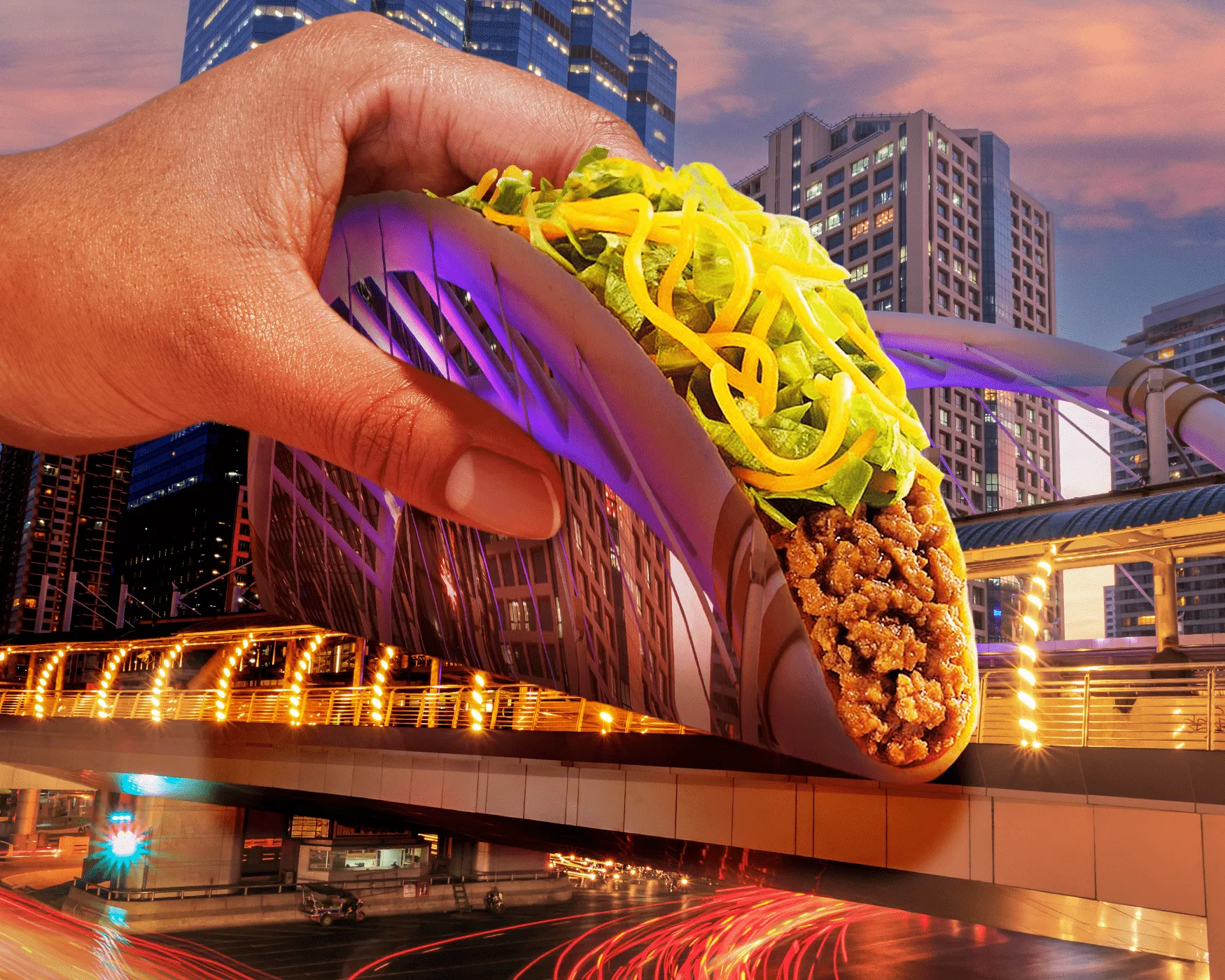 A hand holding a Taco Bell taco built from the Chong Nonsi skywalk in Bangkok