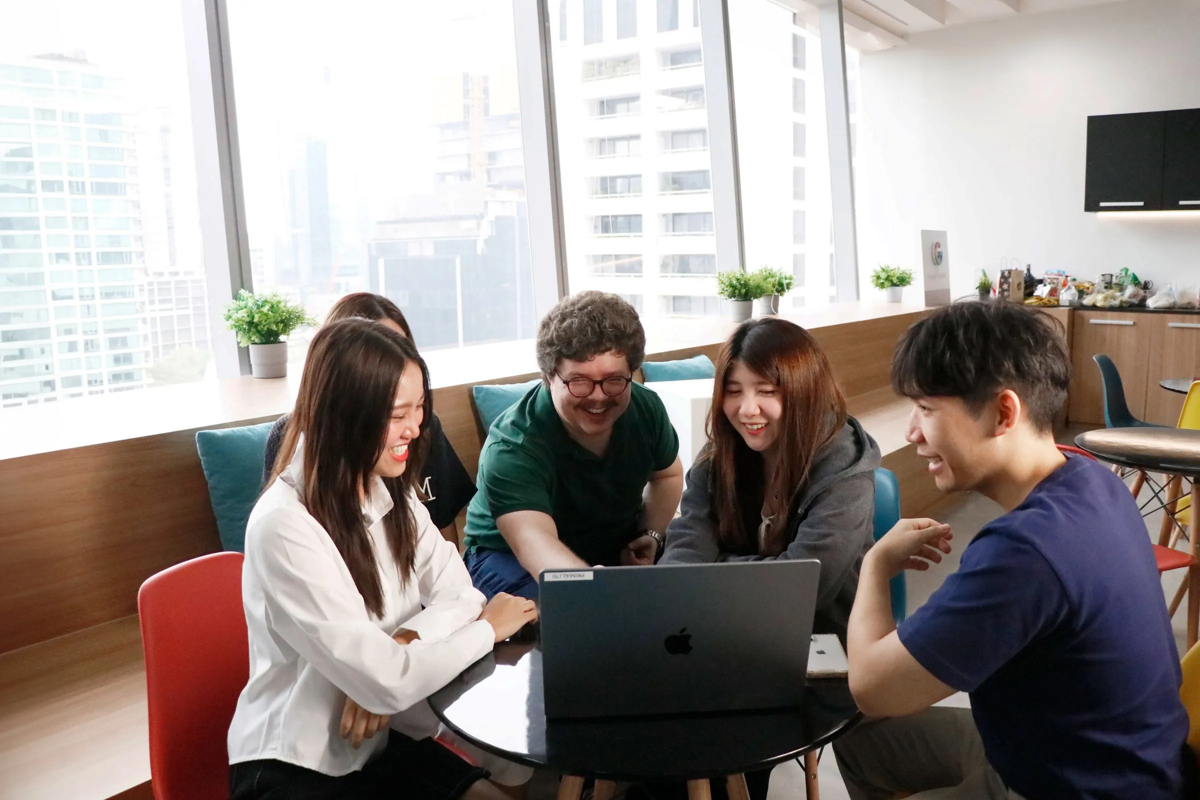 The Primal team working together around a laptop